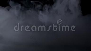 白色的烟雾在黑色的背景下慢慢地飘过空间。 雾效应。 大气烟雾。 雾霾背景